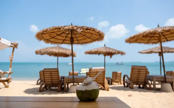 Fresh coconut on a wooden table at a tropical beach