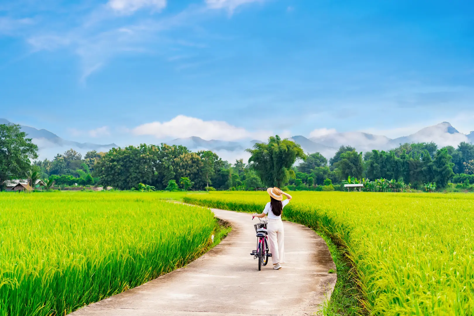 Young tourist smiling while riding a bicycle in Hội An
