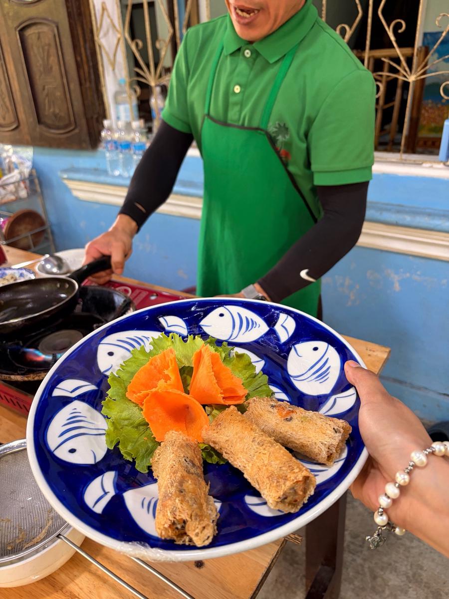 Instructor guiding a guest at the stove